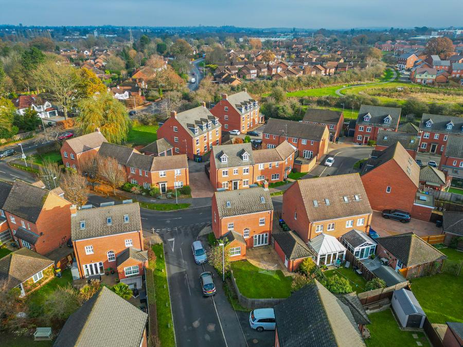 Modern housing development from the air, with countryside beyond the last road