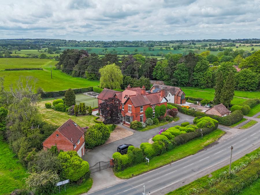 Country house set back from the road, farmland stretching to the horizon