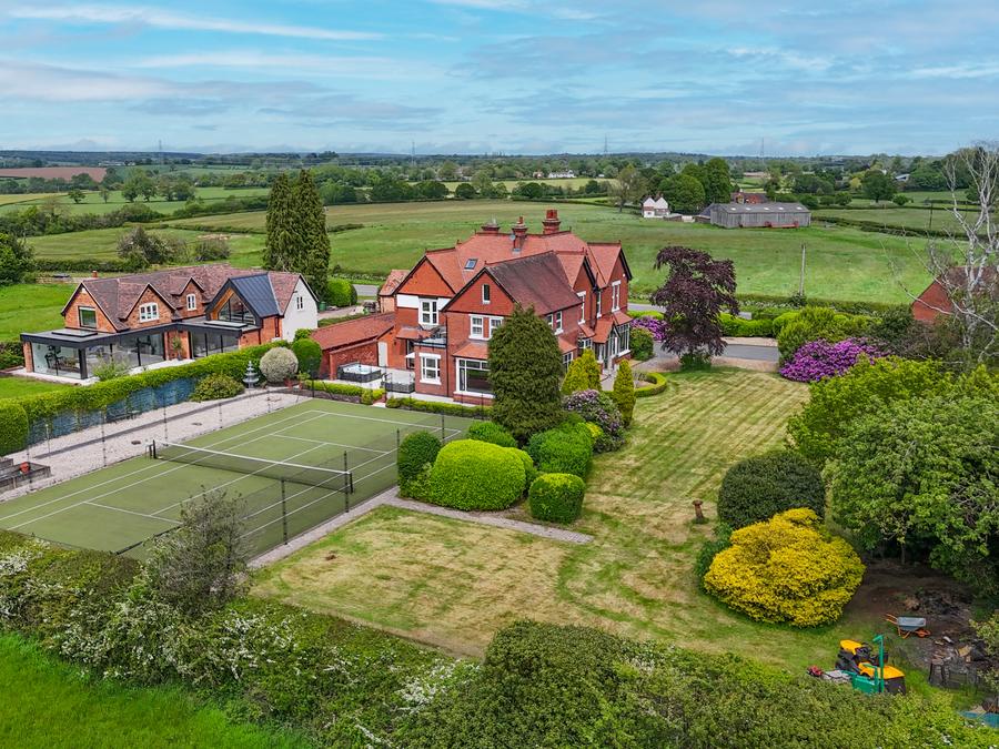 House with a tennis court and gardens, fields running to the skyline