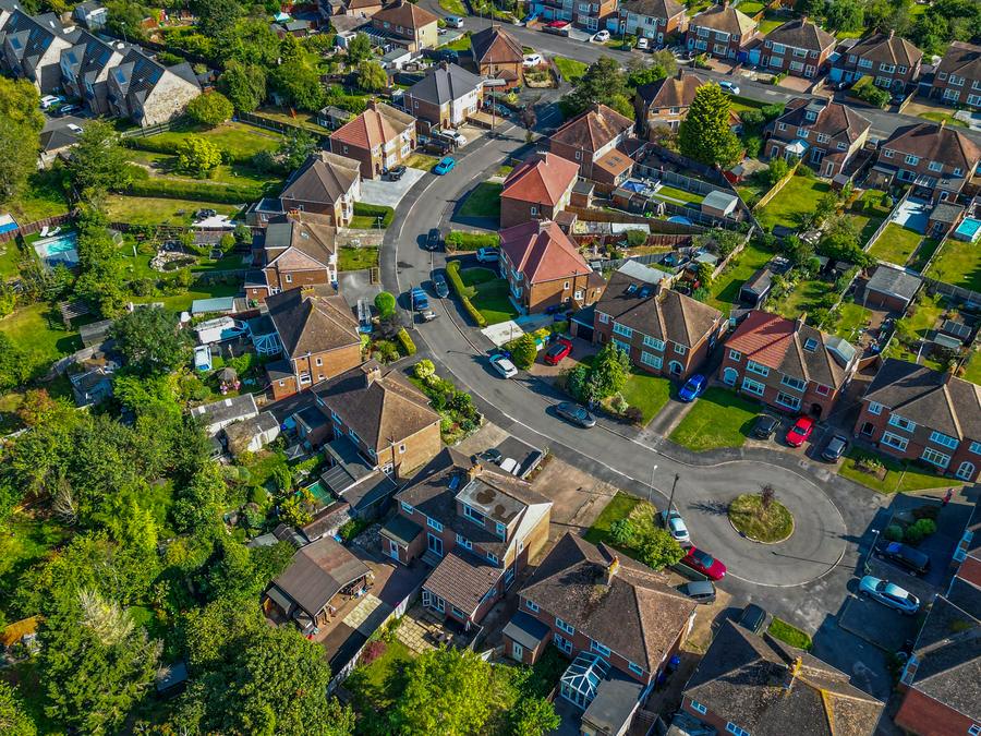 Top-down view over a residential crescent of houses and gardens