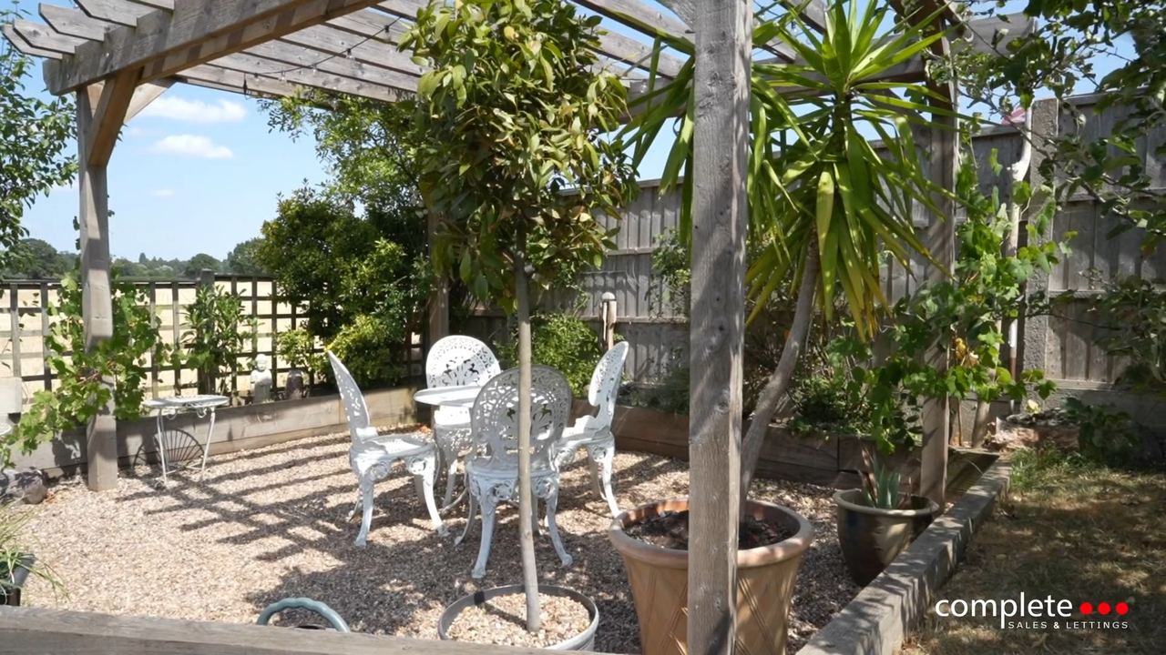 Lamintone Drive: a pergola over a paved terrace with a table and chairs