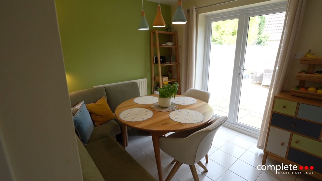 Lady Grey Avenue: a dining nook beside garden doors in a green painted room