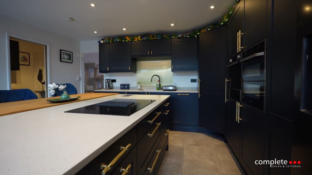 Wellington Road: a navy kitchen with a pale stone island and brass handles