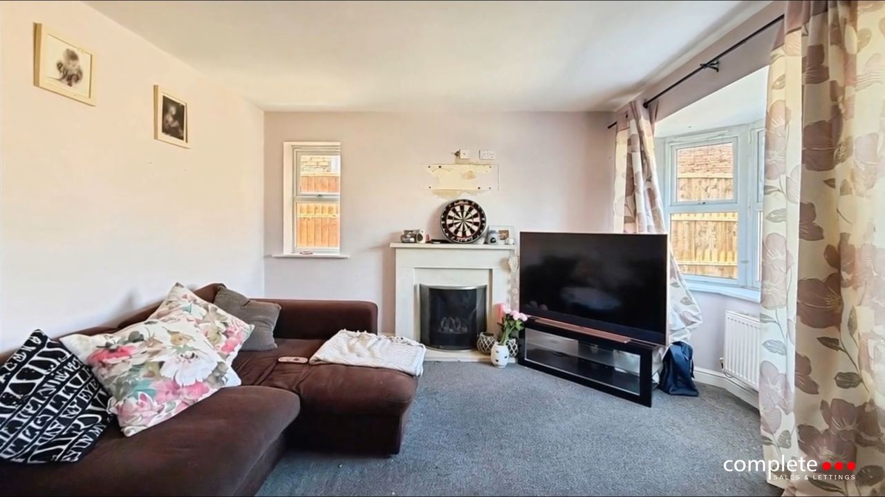 Charingworth Drive: a sitting room with a fireplace and a bay to the garden