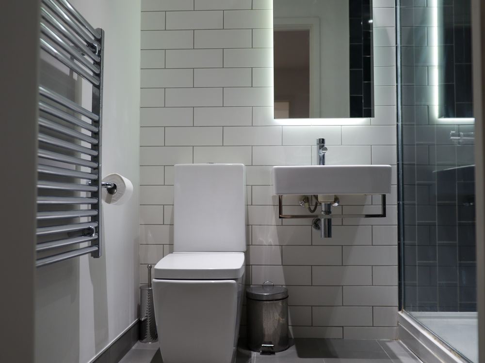 Shower room tiled in white metro brick with a wall-hung basin